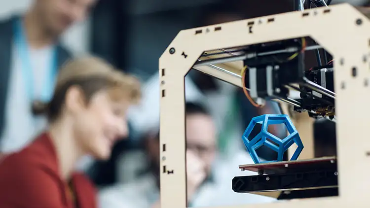 Photo montrant un polygone bleu en cours d'impression sur une imprimante 3D afin de réaliser un prototype